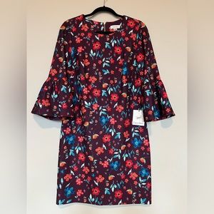 Purple Calvin Klein dress with red and blue flowers and bell sleeves.